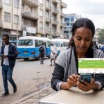 A person holding a smartphone displaying the telebirr mobile money app on a street in Addis Ababa, Ethiopia.